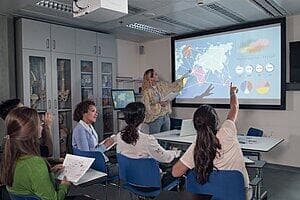 A teacher shows data visualiations to a classroom of students